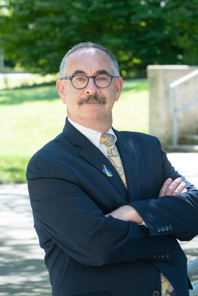 A person with a mustache wearing glasses and a suit

Description automatically generated with low confidence