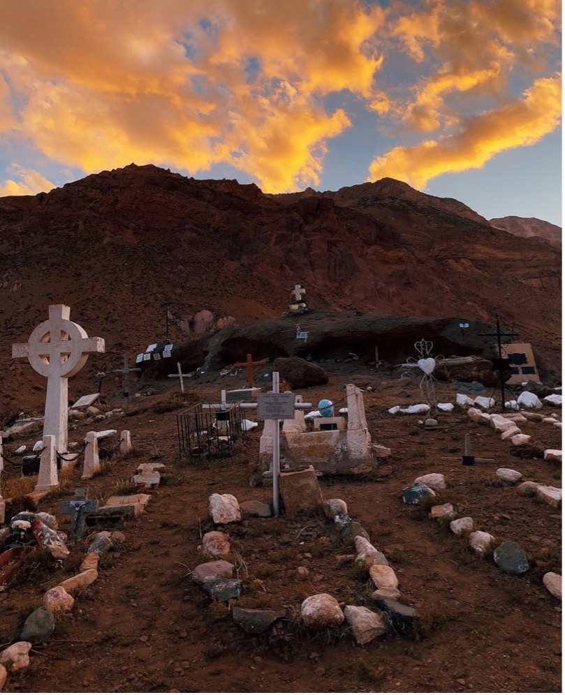 A cemetery with a mountain in the background

Description automatically generated