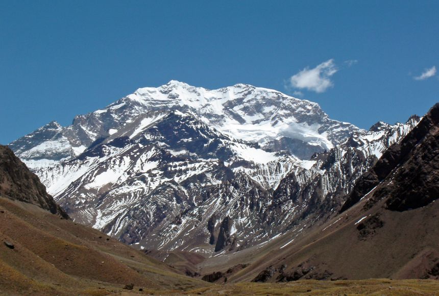 Snow covered Mount Aconcagua in the distance through a valley